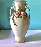 Front view displaying vase shape, floral relief, handles