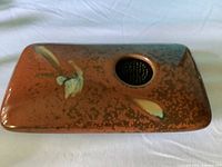 Top view showing brown glaze, abstract motif, round opening with floral frog