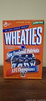 Front of orange Wheaties box showing New England Patriots AFC Champions graphics and product branding