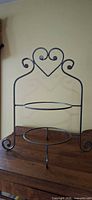front view showing heart handle, two plate rings, scroll feet