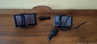 Two Garmin nuvi GPS units with power adapters on table