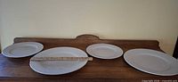 Four plates lined up showing sizes with ruler across larger plate