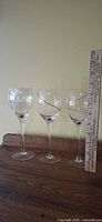 Front view of all three wine glasses next to ruler