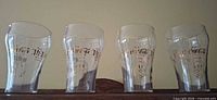 Four Coca-Cola Olympic glasses side by side