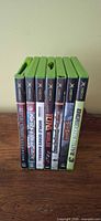 Seven Xbox game cases standing upright showing spines