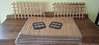 Stack of eight bamboo placemats with two coasters on top and two wooden lattice trivets behind