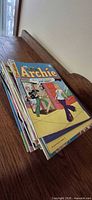 Stack of assorted comics top issue Archie visible