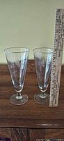 Both beer glasses next to ruler showing height