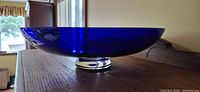 Side view of wide cobalt glass bowl on clear foot