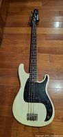 Front view showing cream body, black pickguard, bridge, and missing string
