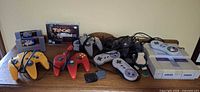 Full lot showing SNES console, six controllers, three game cartridges, boxed game