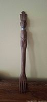 full view of wooden serving fork showing entire length and tines