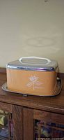 Full view of rectangular metal cake carrier on cabinet