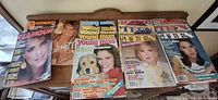 Overview of seven magazines on wooden shelf showing titles Glamour, Mademoiselle, Seventeen, Young Miss, TEEN