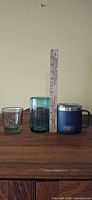 Group shot of clear tumbler, teal tumbler, Yeti mug with ruler for scale