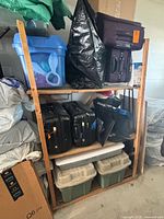 Front view of wooden shelf loaded with bins and suitcases