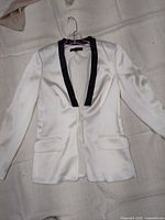 Front view of white satin blazer jacket with black sequin shawl collar