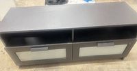 Front view of black IKEA Brimnes TV stand showing two open shelves and two drawers with frosted glass fronts