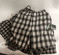 Multiple Solo plaid shorts stacked showing tags and pattern