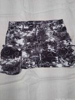Front view of cotton cargo skirt showing button/zip closure, belt loops, cargo pockets and detachable pouch