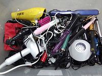 Top-down view of all mixed hair styling tools piled in bin