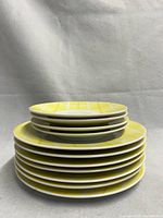 Stack of eleven yellow plaid plates showing sizes