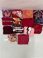 All 14 folded red t-shirts laid out