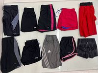 10 pairs of shorts laid out, showing Nike, Adidas and Lululemon items