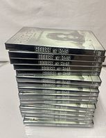 Stack of fifteen shrink-wrapped “House of Bad” DVDs, spines visible