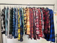Rack with 28 multicoloured plaid flannel shirts