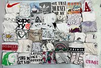 Top view of all 39 folded white graphic shirts displayed in five rows