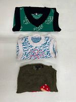 All three vests stacked to show colours and patterns