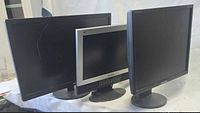 Front view of three LCD monitors with stands