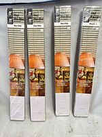 Four sealed boxes of Lumino vinyl mini blinds standing upright