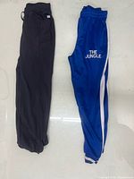 Black and blue sweatpants laid side by side