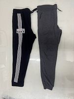 Black track pant and grey jogger laid flat