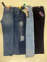 Five jeans side-by-side showing washes and tags