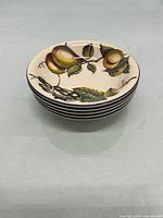Stack of five matching fruit-decorated bowls