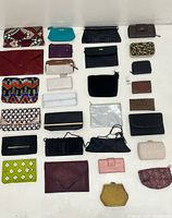 Top-down view of 31 clutches and wallets in various colours and styles arranged in rows