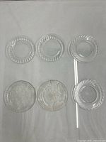 Six clear patterned plates laid out to show full set and patterns