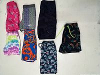 All seven pairs of swim trunks laid out flat showing patterns and colours