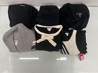 Six of the eight folded new-with-tags Mossimo and Xhilaration sweaters showing colours, knit styles and tags