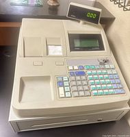 Front angled view of Royal Alpha 9500ML cash register showing keypad, receipt printer, customer display and cash drawer
