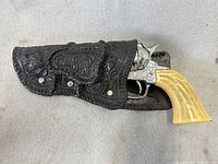 Toy revolver inside tooled leather holster