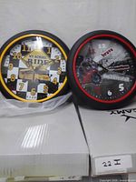 Front view of both wall clocks showing designs and condition