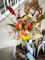 Full view of mixed silk flower arrangement in glass vase on table