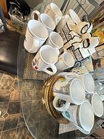 Group of assorted mugs and ceramic gift box on table