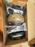 Box containing assorted glasses, white sunglasses, reptile and black cases