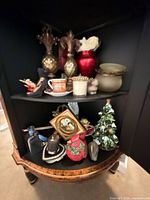 Cabinet shelves with multiple figurines, glass jars, finials and framed cameo