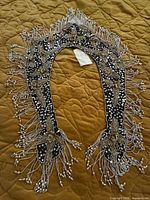 Full view of beaded collar showing shape, embellishment and fringe